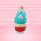 Cute kawaii bunny blue ice cream tall sundae that has red, white and blue layers in the dish and a strawberry on top near the whipped cream and pearls. The photo is taken from the back.