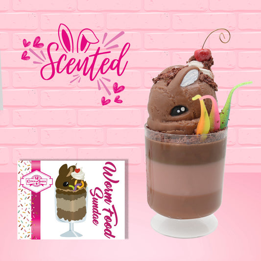 Cute kawaii bunny tall brown and light brown ice cream sundae with brown chocolate crumbles over the bunny, with a cherry on top of the whipped cream swirl.  Three bendy gummy worms are in the dish on the side. The front of the character card is shown as well as the word scented.