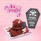 Cute kawaii red bunny on top of a brown waffle with red and brown drizzles, coco bits, and tombstone on a square plate. The sign says Waffles Death by Chocolate, Beware if you dare and the word scented is shown.