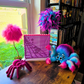Colorful spiders and toys on a wooden surface with a window and enamel Board in use in a room.