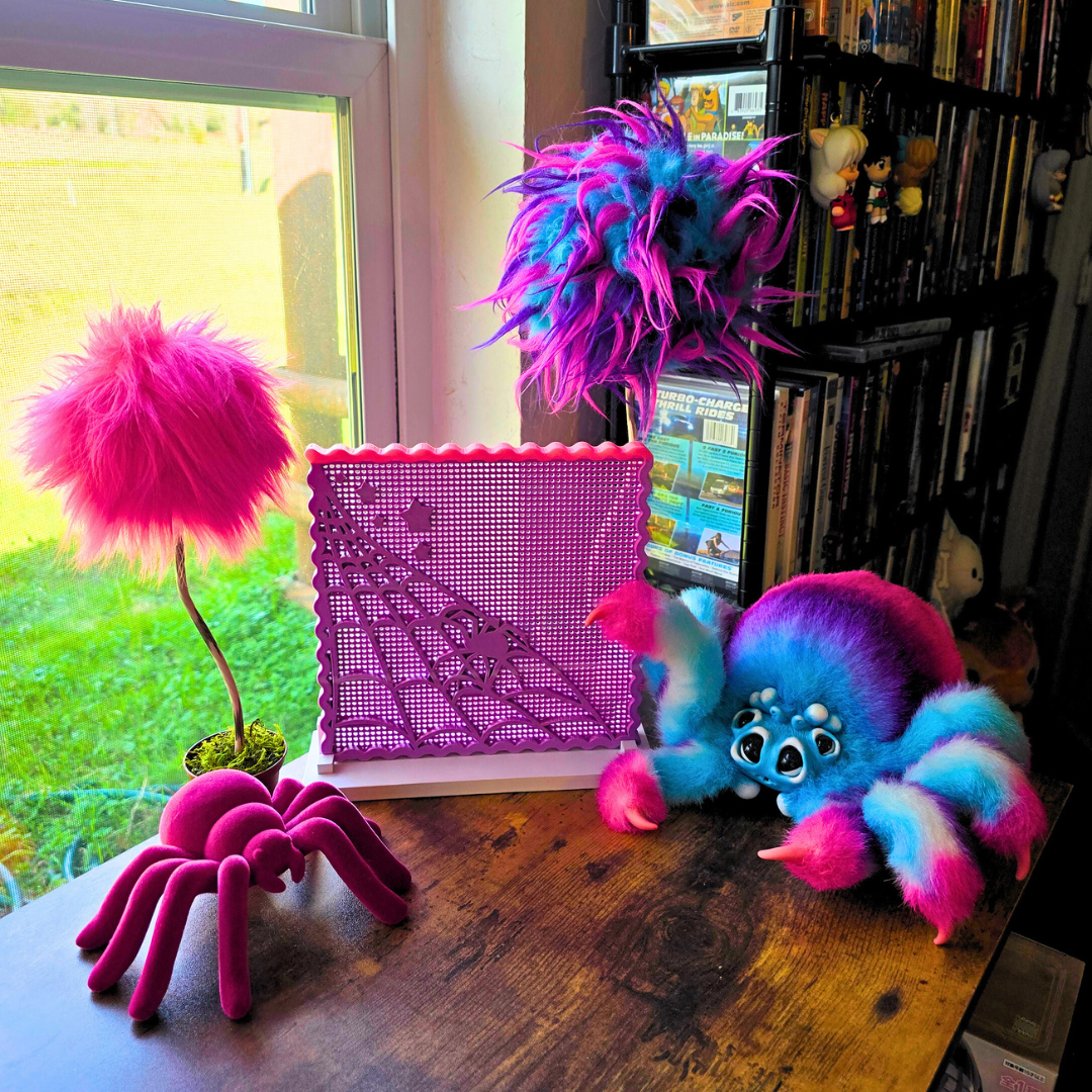 Colorful spiders and toys on a wooden surface with a window and enamel Board in use in a room.